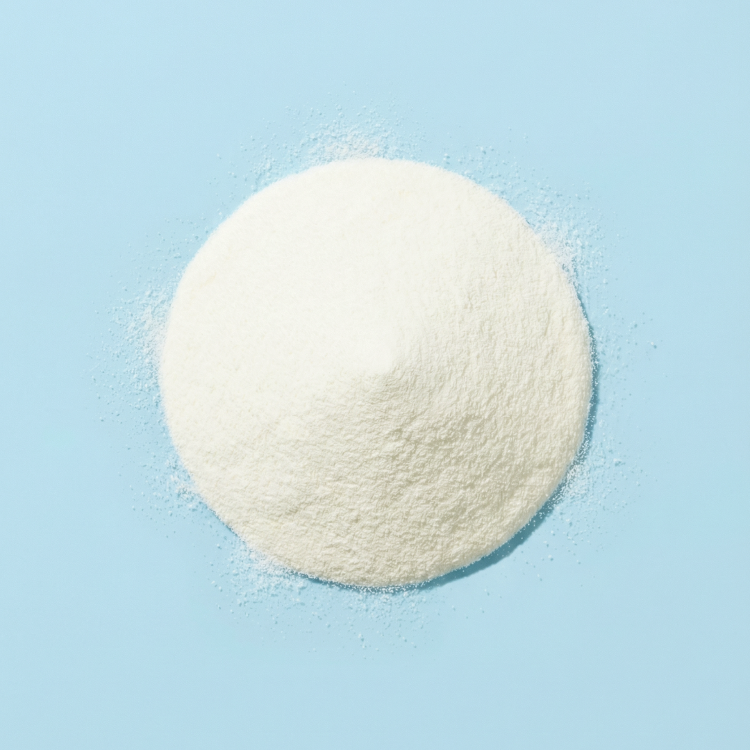 Round scoop of Super Collagen Peptides white powder on a light blue background